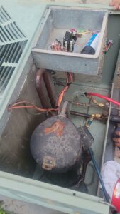 An AC compressor and internal components being serviced by Brothers Heating & Cooling Inc. in Chicago, IL.