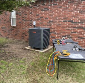 Chapman HVAC performing service or installation on an AC condenser unit with tools in Cleveland, OK.