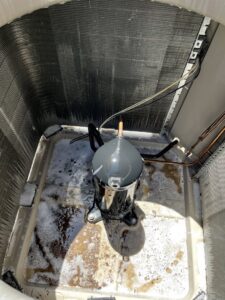 An AC condenser unit being cleaned during maintenance by The Heating & Cooling Company LLC in Las Vegas, NV.