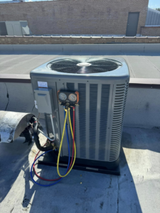 An AC condenser unit undergoing diagnostics with gauges by Four Stages, an HVAC contractor in Chicago, IL.