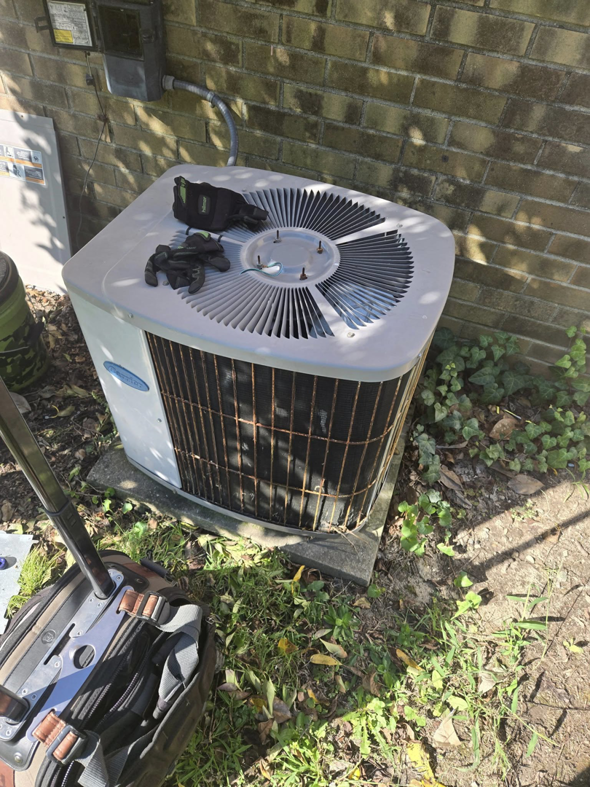 An outdoor AC condenser unit undergoing maintenance or repair by Jesse's HVAC LLC in Newport News, VA.