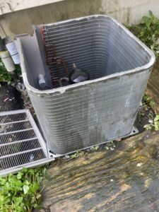 An outdoor AC condenser unit with its top removed for repair or maintenance by Manny Services in Syracuse, NY.