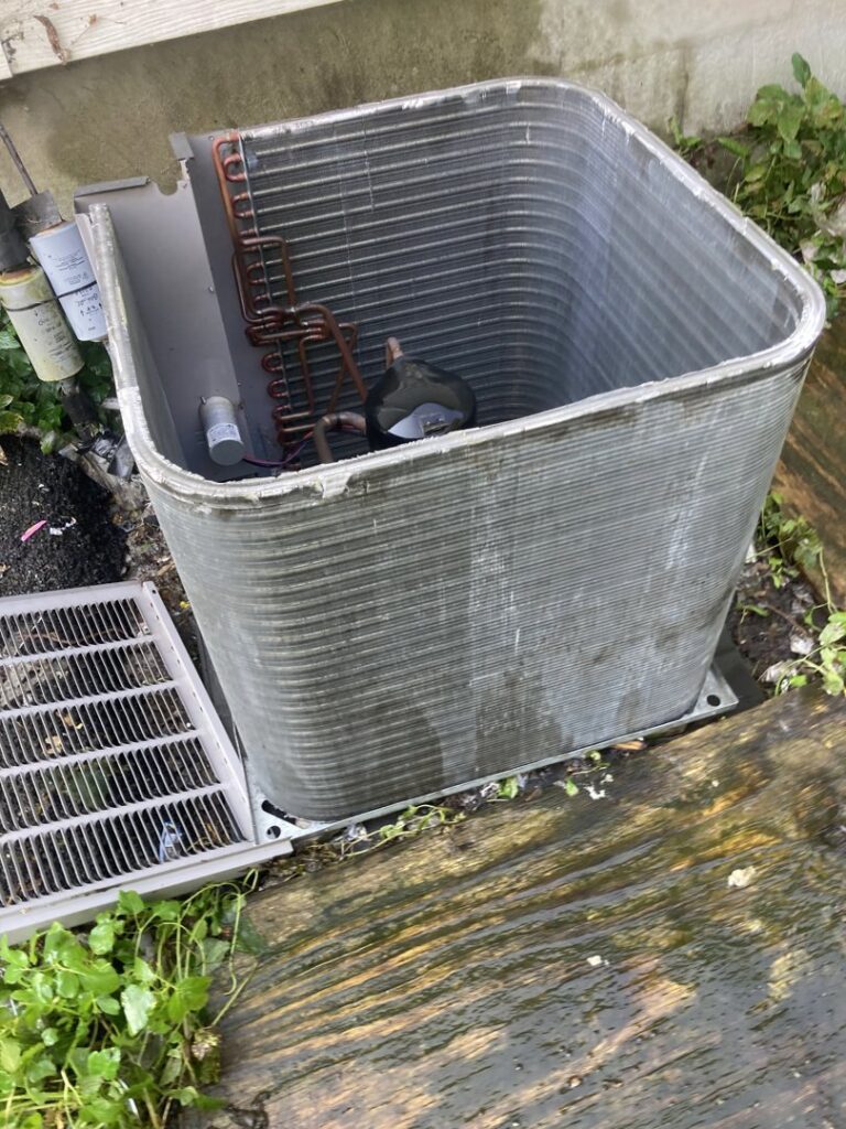 An outdoor AC condenser unit with its top removed for repair or maintenance by Manny Services in Syracuse, NY.