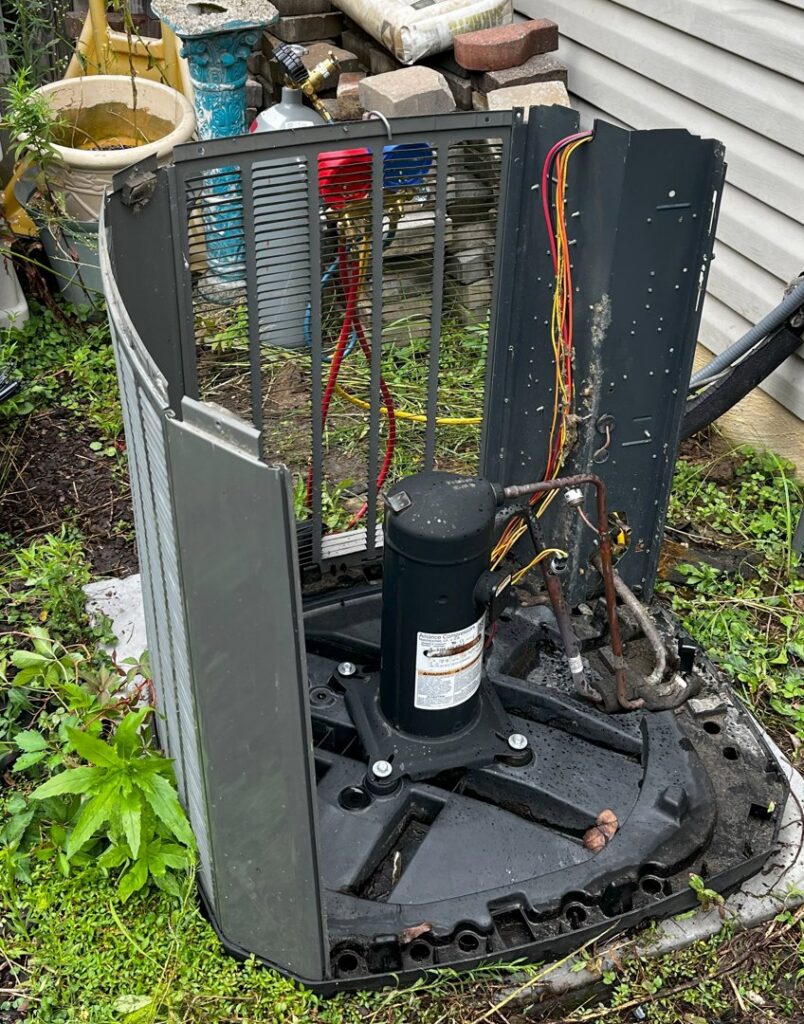 An outdoor AC condenser unit undergoing repair or service with gauges connected by Infinite Heating & Air in Newnan, GA.