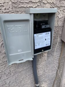 A close-up of an A/C disconnect box installed on the side of a house by Klee's Climate Control in Mesa, AZ.
