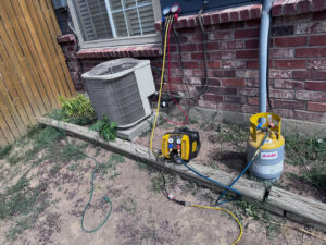 An outdoor air conditioning unit being recharged with refrigerant by Primary Air Home Services in Aurora, CO.