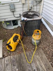 An HVAC technician performing an AC refrigerant recharge service for Wilcox Services in Temple Hills, MD.