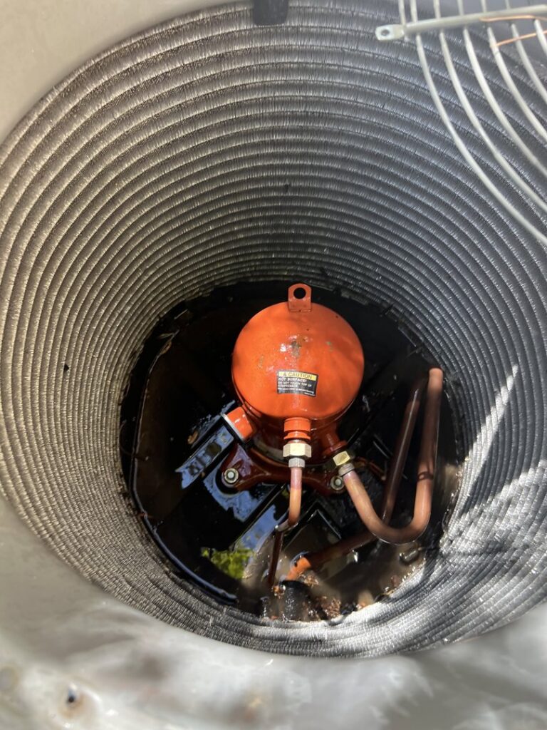 Close-up view of an AC unit's compressor and coils during an inspection by Usa Air Conditioning & Heating in Las Vegas, NV