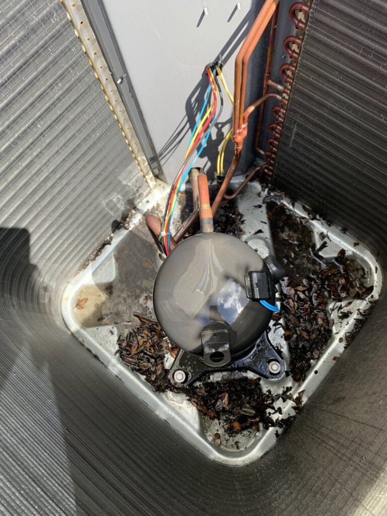 An air conditioning unit's compressor surrounded by debris, indicating a need for service by PureAir HVAC in Bel Air, MD.