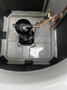 An inside view of an outdoor AC unit showing the compressor, indicating service by All Around Heating & Cooling in Akron, OH.