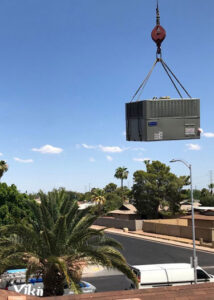 An AC unit being lifted by a crane for installation or removal by Viking Heating and Air Conditioning, LLC in Chandler, AZ