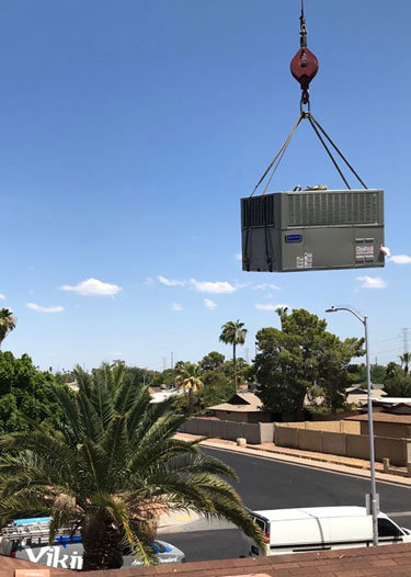 An AC unit being lifted by a crane for installation or removal by Viking Heating and Air Conditioning, LLC in Chandler, AZ