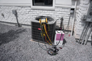 An outdoor AC unit undergoing diagnostic and service with gauges and tools by CSA HVAC Services in Orem, UT.