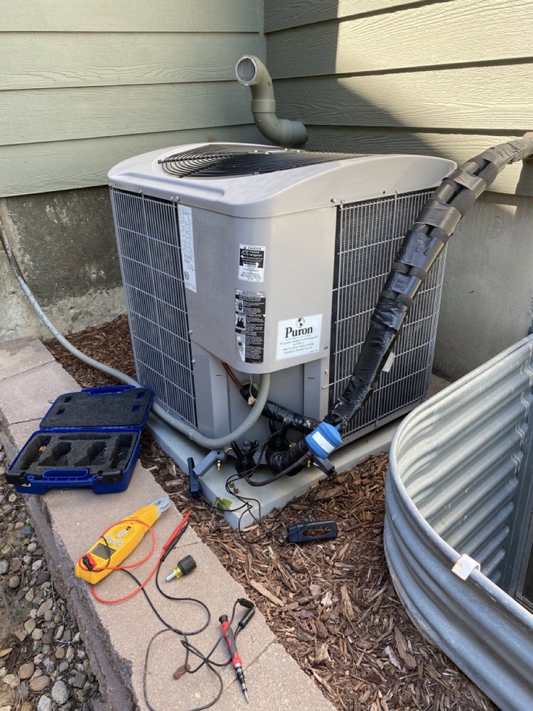 An outdoor air conditioning unit undergoing diagnostic service with tools laid out by Jump HVAC in Lakewood, CO.