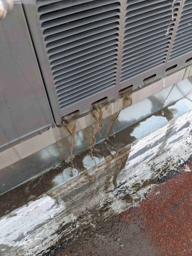 Water and grime dripping from an outdoor air conditioning unit, indicating a drainage issue or cleaning by Sahara Air Conditioning & Heating in Las Vegas, NV