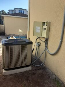 An outdoor AC unit with electrical conduit and disconnect box installed by Positricity in Clearwater, FL.