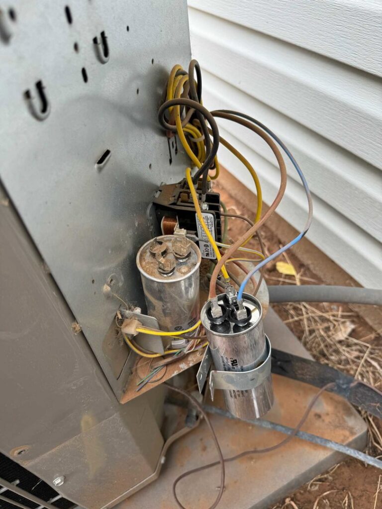 Close-up of electrical components and wiring inside an outdoor AC unit, serviced by Diamond L Plumbing & HVAC in Salt Lake City, UT.