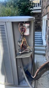 Electrical components and wiring inside an outdoor AC unit during a repair by Primary Air Home Services in Aurora, CO.