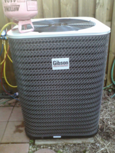 An outdoor AC unit undergoing maintenance with refrigerant gauges connected by Allwaysthere Heating and Cooling in Frederick, MD