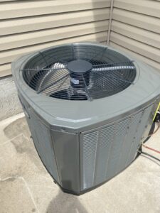 An outdoor air conditioning condenser unit undergoing maintenance service by Breeze Heating & Cooling Nashville in Nolensville, TN.