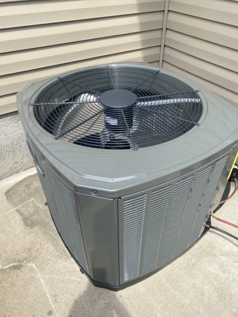 An outdoor air conditioning condenser unit undergoing maintenance service by Breeze Heating & Cooling Nashville in Nolensville, TN.
