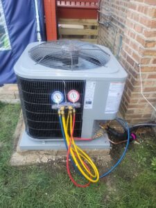 An outdoor AC unit with refrigerant gauges connected for charging by Brothers Heating & Cooling Inc. in Chicago, IL.