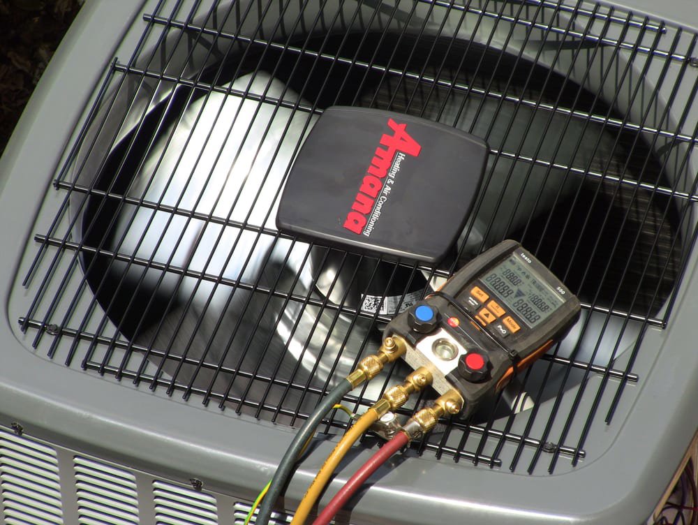 A technician performing a refrigerant check on an Amana outdoor AC unit for Around The Town Heating and Cooling in Chicago, IL.
