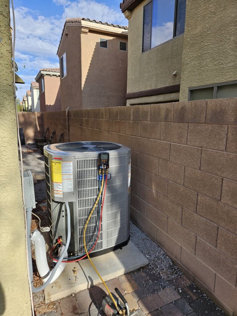 An outdoor AC unit with refrigerant gauges connected for service by Tanana Air Conditioning & Heating in Las Vegas, NV.