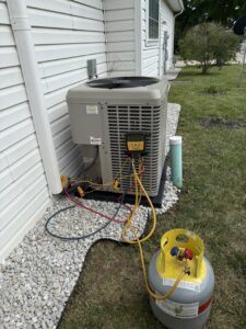An outdoor AC unit undergoing refrigerant recharge or service by 4-BIS Solutions HVAC and Home Maintenance in Columbia, MO.
