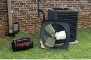 An outdoor air conditioning unit undergoing repair or maintenance with its fan removed, showing tools from Netherland Air Conditioning LLC in Mobile, AL.