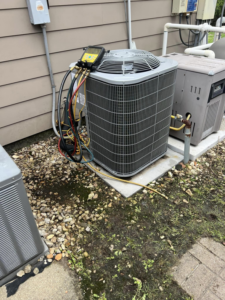 An outdoor AC unit being serviced with refrigerant gauges by Comfort Zone AC and Heating Services LLC in Sunrise Beach, MO