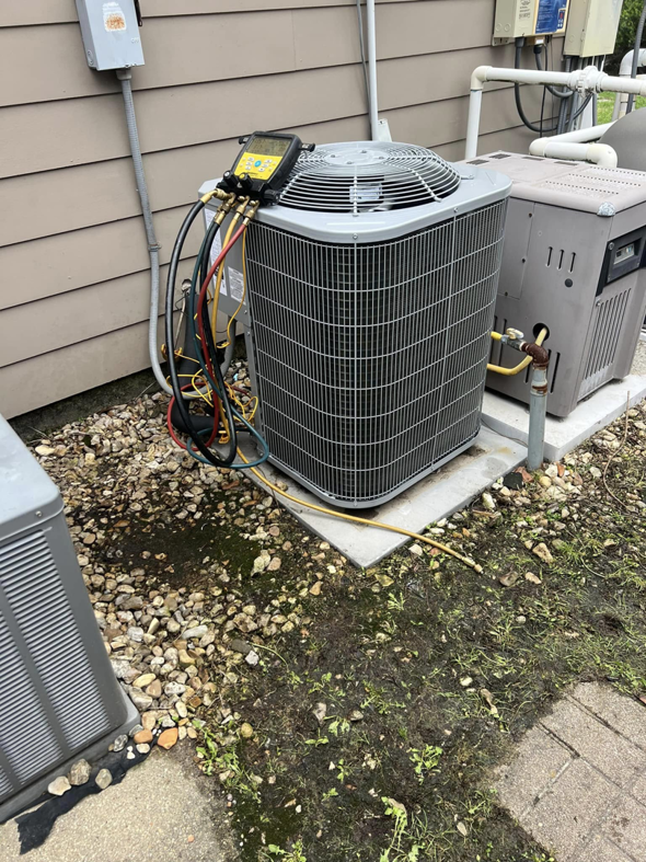 An outdoor AC unit being serviced with refrigerant gauges by Comfort Zone AC and Heating Services LLC in Sunrise Beach, MO