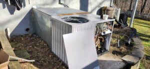 An outdoor AC unit with its panel open, showing internal components during a service by Recovery HVAC in Smyrna, TN.