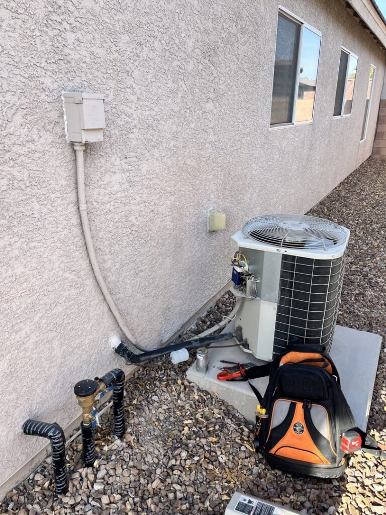 An outdoor AC unit undergoing repair or service with tools nearby by The Heating & Cooling Company LLC in Las Vegas, NV.