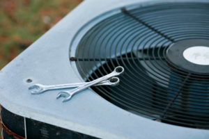 Wrenches resting on an outdoor air conditioning unit, symbolizing AC repair services from Climate Control in San Antonio, TX