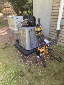 An outdoor air conditioning unit being serviced or installed by Call The Bee Plumbing, Heating, Air & Electric in Farmington, CT.