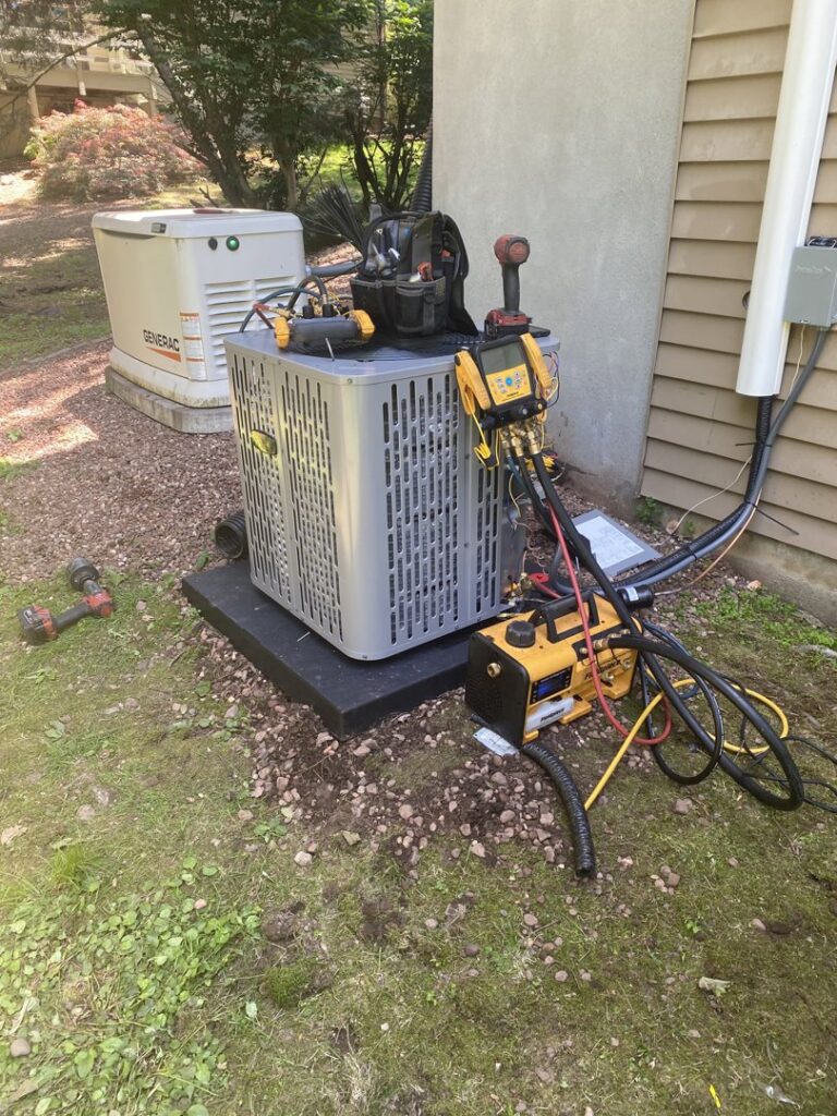 An outdoor air conditioning unit being serviced or installed by Call The Bee Plumbing, Heating, Air & Electric in Farmington, CT.