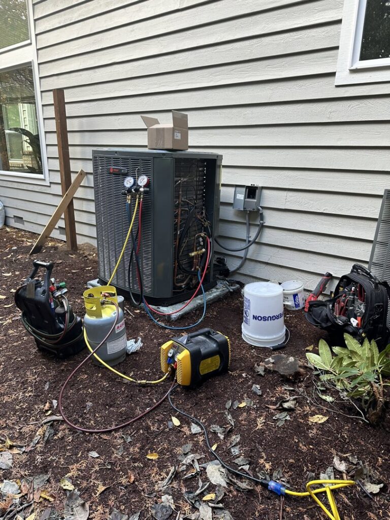 Outdoor AC unit being serviced with refrigerant gauges and tools by GreenFlow Heating & Cooling in Tacoma, WA