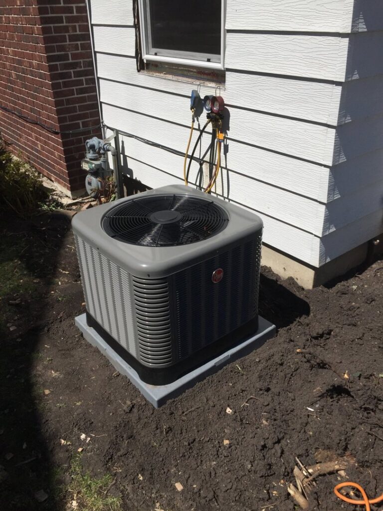 An outdoor air conditioning unit being serviced with gauges connected by The Heating Guys in Fargo, ND.