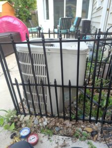 An outdoor AC unit being serviced with refrigerant gauges by I & M Heating and Cooling in South Bend, IN.