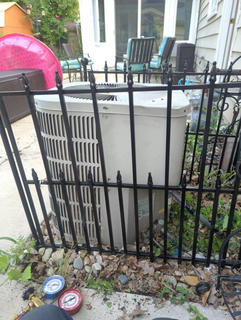 An outdoor AC unit being serviced with refrigerant gauges by I & M Heating and Cooling in South Bend, IN.