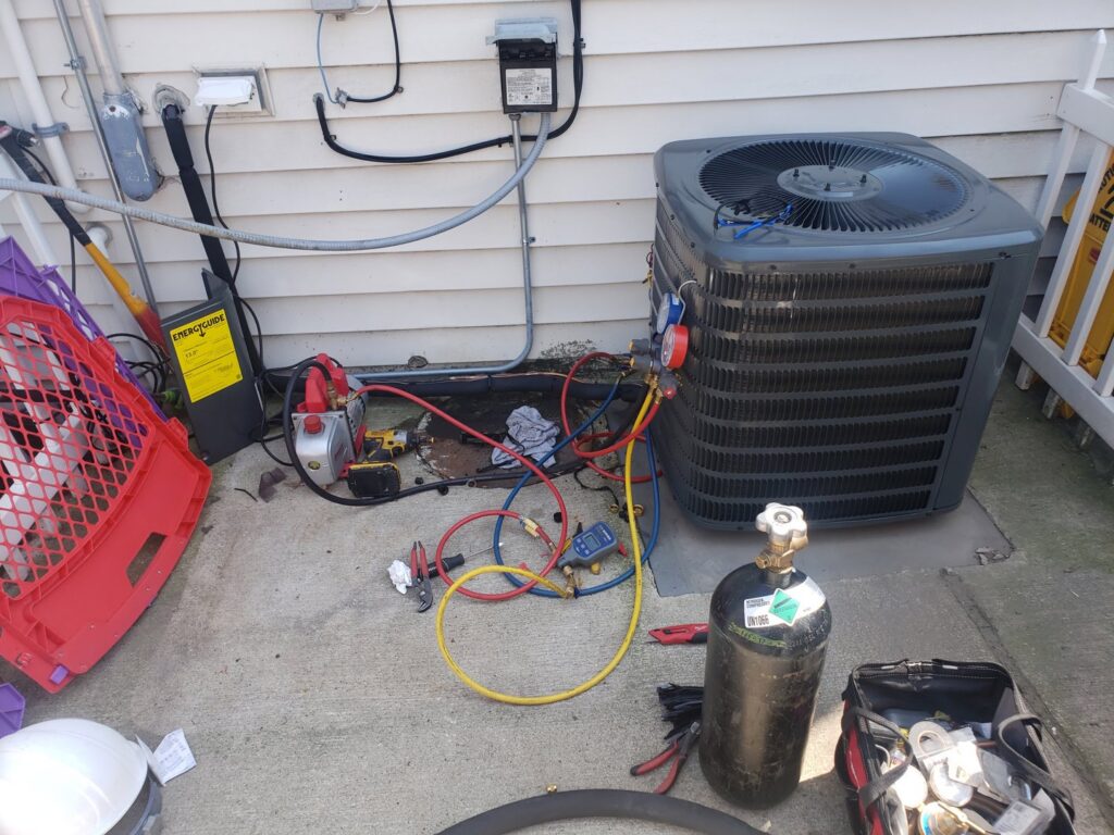 An outdoor AC unit being serviced with a vacuum pump and gauges by Brothers Heating & Cooling Inc. in Chicago, IL.