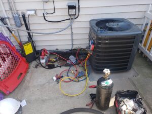 An outdoor AC unit being serviced with a vacuum pump and gauges by Brothers Heating & Cooling Inc. in Chicago, IL.