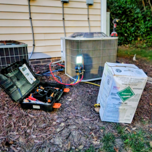 An outdoor air conditioning unit with refrigerant gauges connected during a service call by Whittington HVAC in King, NC.