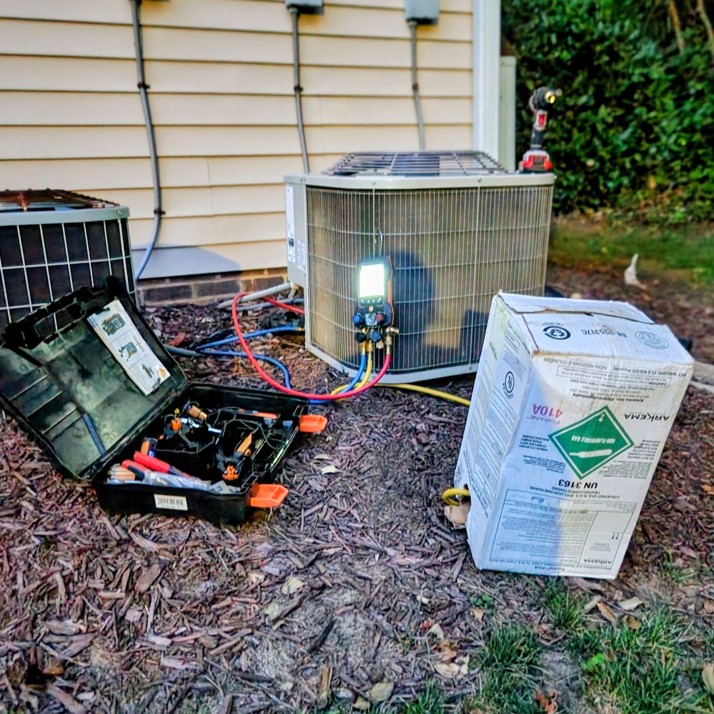 An outdoor air conditioning unit with refrigerant gauges connected during a service call by Whittington HVAC in King, NC.