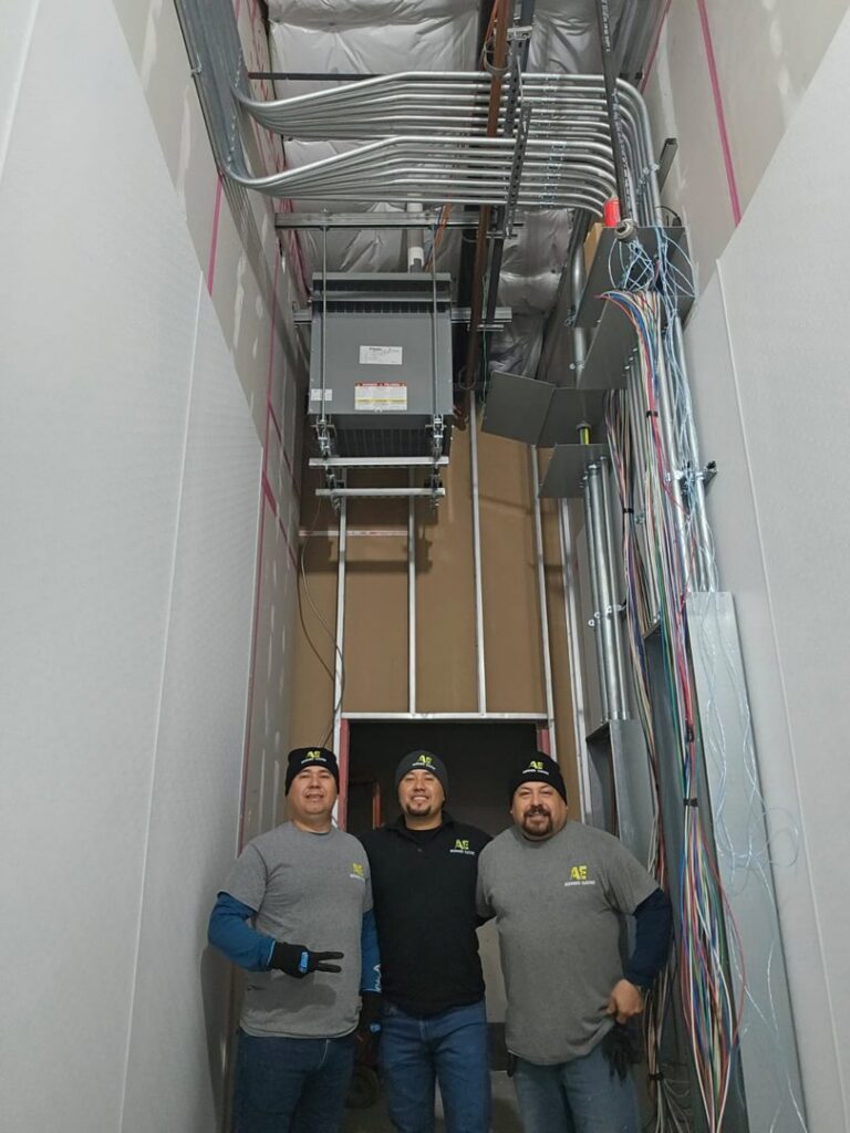 The Acevedo's Electric team posing with newly installed electrical conduit and equipment in Dallas, TX.