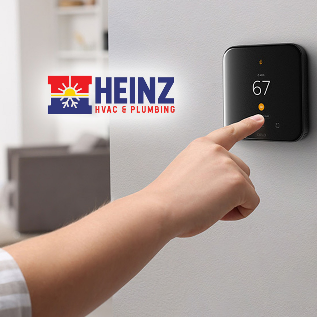 A hand adjusting a smart thermostat, representing HVAC control services by Heinz HVAC & Plumbing in Vincennes, IN.