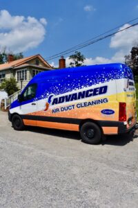 An Advanced HVAC and Plumbing air duct cleaning service van parked on a street in Morgantown, WV.
