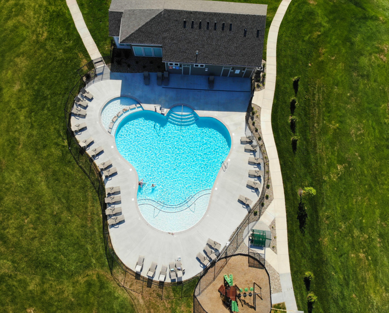 An aerial view of a custom-shaped community pool with a playground built by Midwest Custom Pools, LLC in Lawrence, KS.