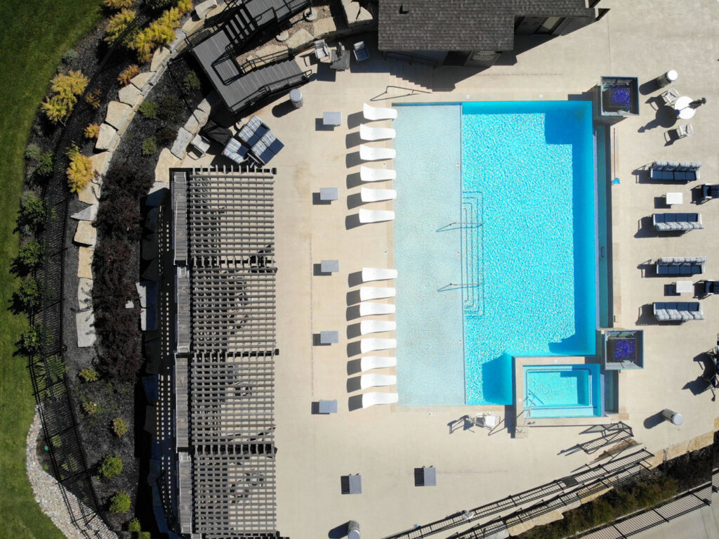 An aerial view of a rectangular pool with a spa and patio by Midwest Custom Pools, LLC in Lawrence, KS.